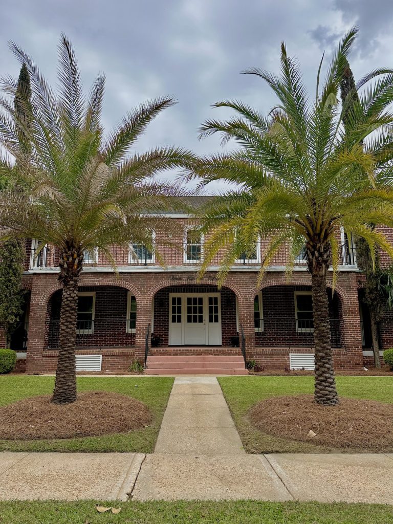 Front exterior of 715 1st St SE Apartments with brick arches and palm trees, Moultrie, GA